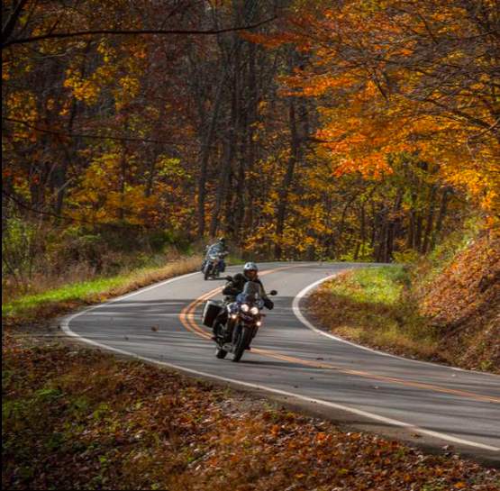 Riders taking a curve through fall foliage