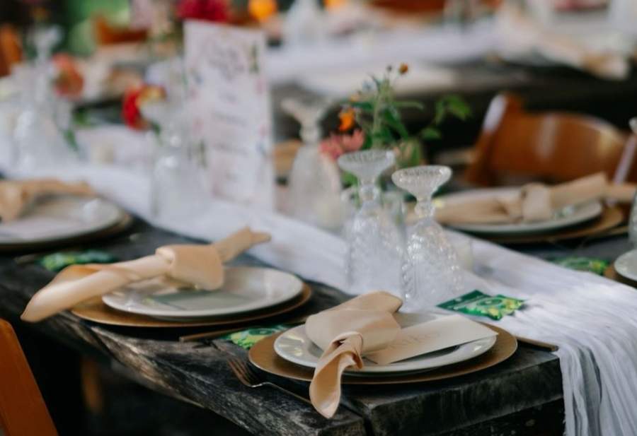 Formally set long dining table with glassware and florals